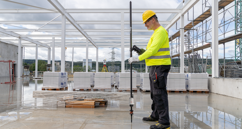 Leica iCON build for structures, showing construction workers laying out points on a construction site with the Leica AP20 Autopole.